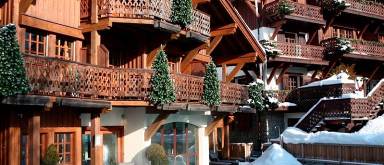 Chalés de madeira do Hotel Four Seasons Hotel Megeve, com piscina aquecida ao ar livre.