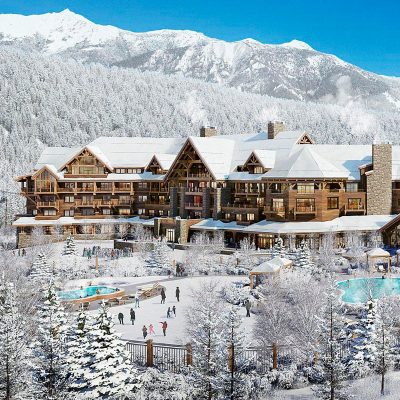 Hotel nas montanhas cobertas de neve com pista de patinação e pessoas ao redor.