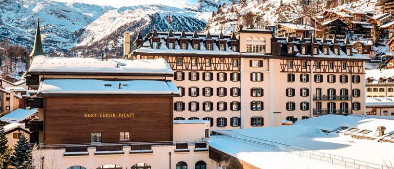 Hotel de luxo em meio às montanhas cobertas de neve, com o Matterhorn ao fundo.